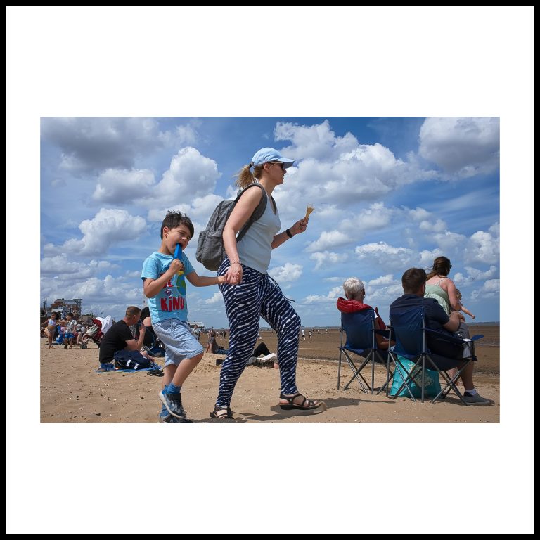street photographer stewart wall captures a mother and shild eating ice cream on the cleethorpes beach at the air show in 2022